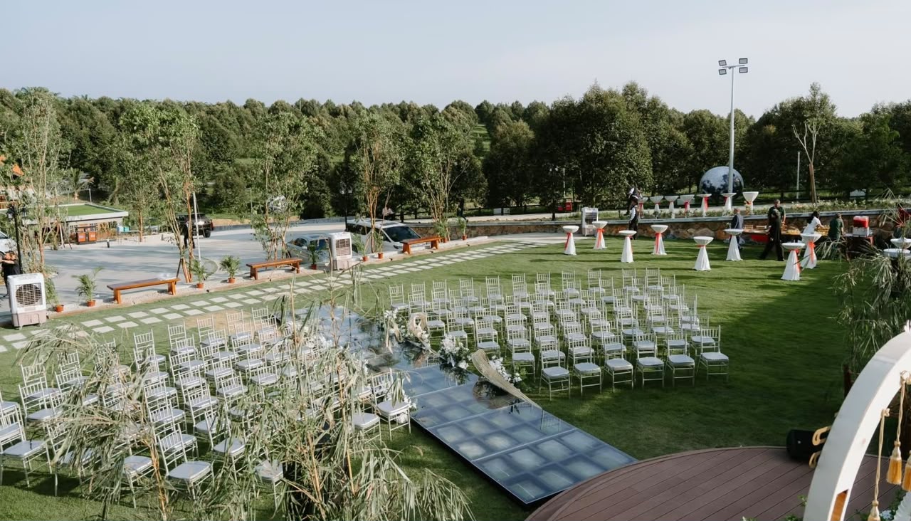 Outdoor garden with a green lawn, ceremony seating and surrounding trees